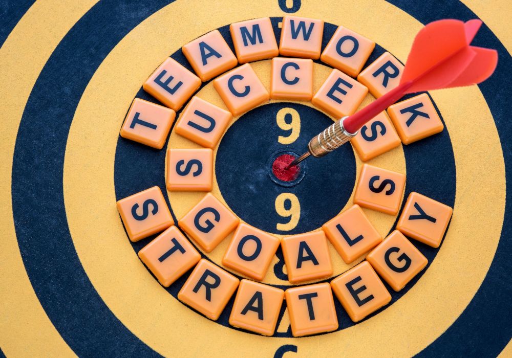 dart target on bullseye with success goals teamwork strategy words, Goal target success business investment financial strategy concept, abstract background